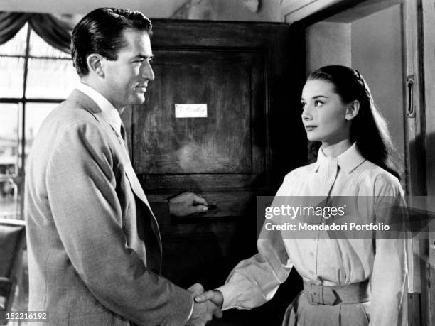 Gregory Peck, as the journalist Joe, shaking the hand of Audrey Hepburn, Princess Ann, in a scende from the movie Roman Holiday. Rome, 1953.