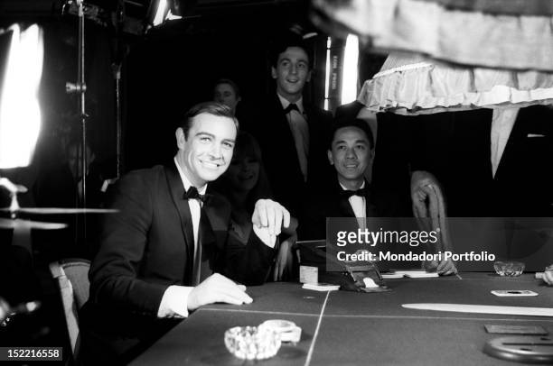 The actor Sean Connery smiles at a photographer during a break in the shooting of a scene at the casino from the movie Thunderball, fourth episode of...