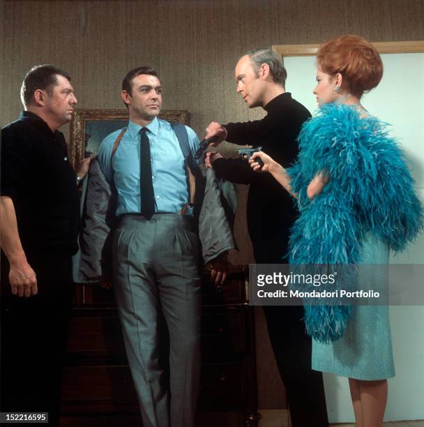 Luciana Paluzzi, with two killers' aid, threatens Sean Connery at gun-point in a scene from "Thunderball" by Terence Young, fourth episode of secret...