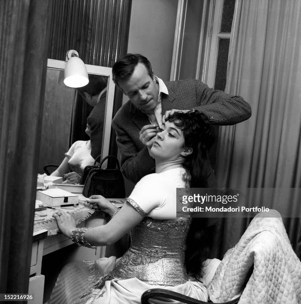 Franco Zeffirelli takes care of Fiorenza Cossotto's make up in the dressing room. Milan, April 1963.