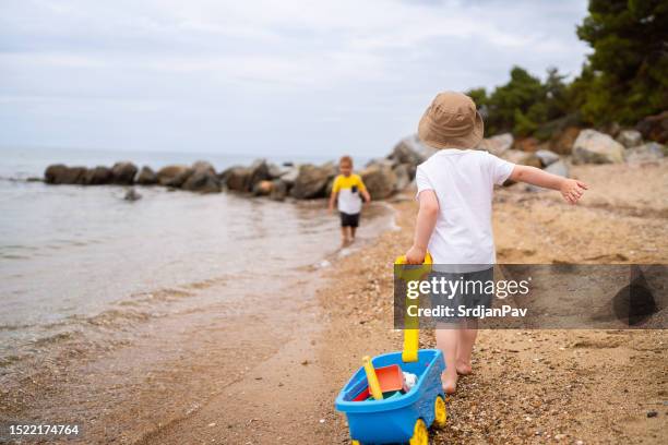due fratellini che giocano sulla spiaggia - solo bambini maschi foto e immagini stock