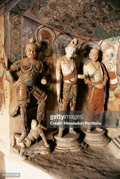 In the wall of a Buddhist temple, dug inside Mogao cave number 45, there is a niche containing three statues made of painted stucco, belonging to...