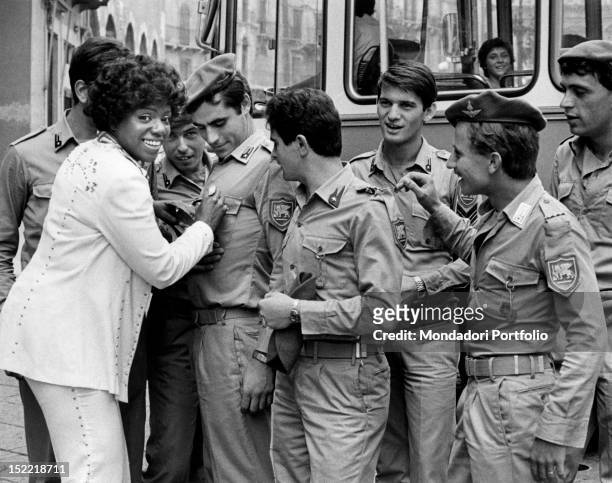 American singer Gloria Gaynor, star of the disco era, joking with some officerse during her tour in Verona. Verona , 1975.