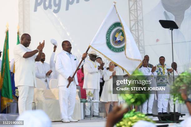Gabon President Ali Bongo Ondimba waves the Gabonese Democratic Party flag at the Nzang Ayong stadium in Libreville on July 10 a day after he...