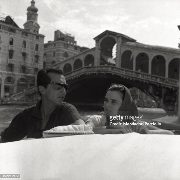 The Italian actress Lucia Bosè with her Spanish bullfighter husband Luis Miguel Dominguin on a boat in the vicinity of Rialto bridge. Venice, 1956.