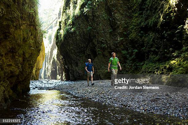 two men hiking a narrow canyon. - columbia river gorge stock pictures, royalty-free photos & images