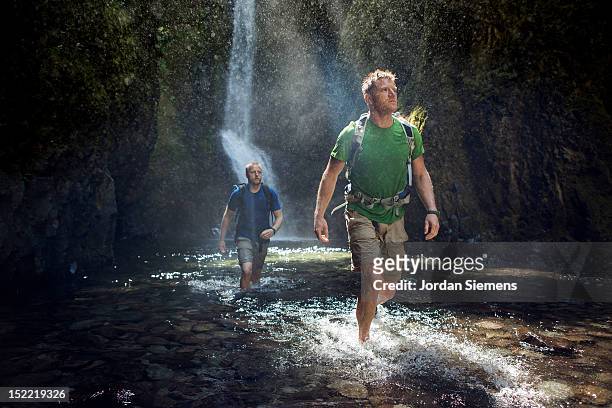 two men hiking a narrow canyon. - turismo ecológico fotografías e imágenes de stock