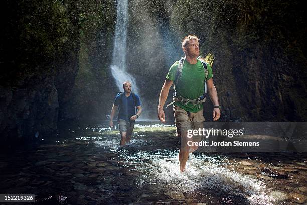 two men hiking a narrow canyon. - ankle deep in water stock pictures, royalty-free photos & images