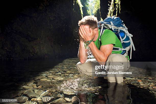 a man hiking a narrow canyon filled with water. - oneonta falls stock pictures, royalty-free photos & images