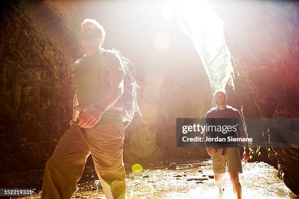 Two men hiking a narrow canyon.