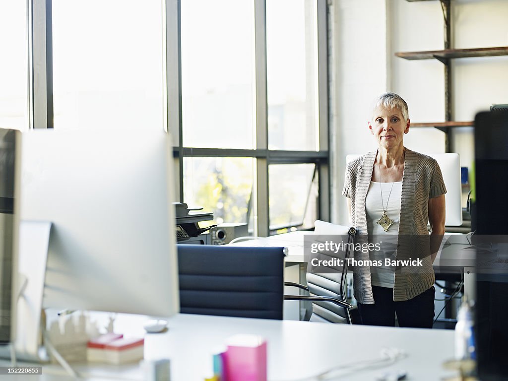 Mature businesswoman standing in high tech office