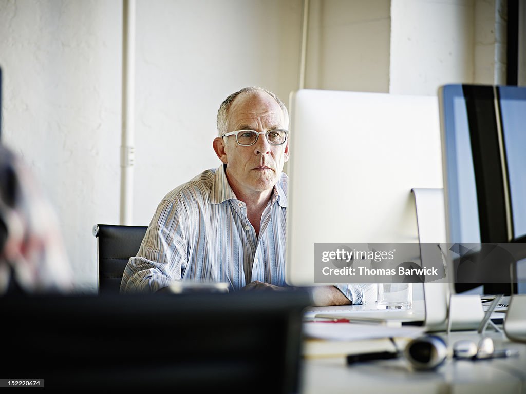 Mature businessman looking at computer monitor