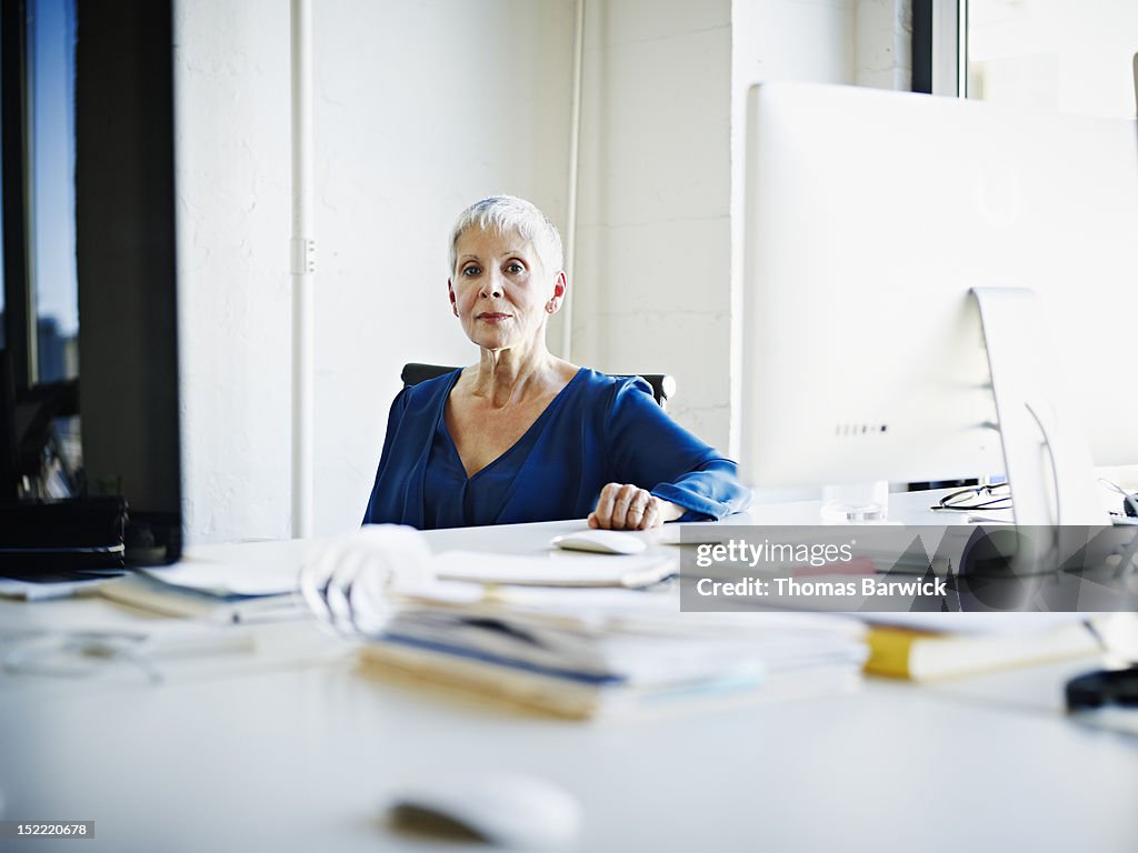 Businesswoman sitting at desk in office portrait