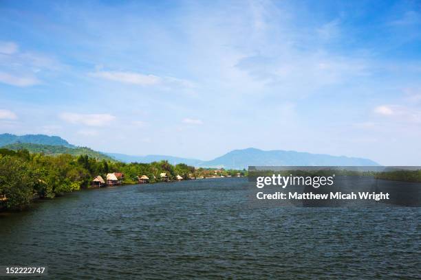 bungalows line the riverside on this river. - kampot stock pictures, royalty-free photos & images