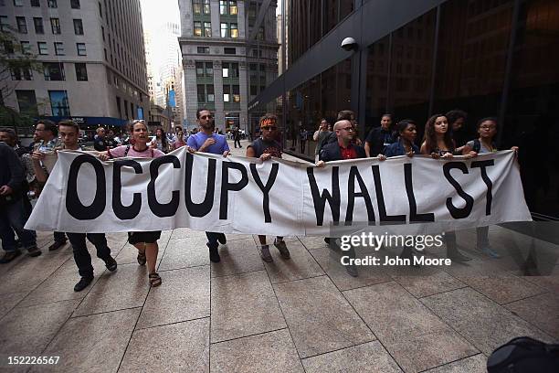 Protesters march near the New York Stock Exchange during a demonstration marking the one-year anniversary of the Occupy Wall Street movement on...