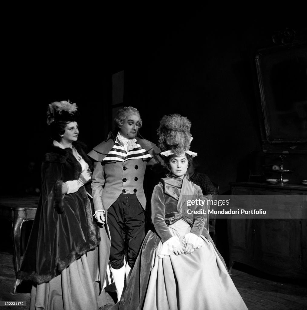 Pina Cei and Alfredo Bianchini converse behind Fulvia Mammi, who is