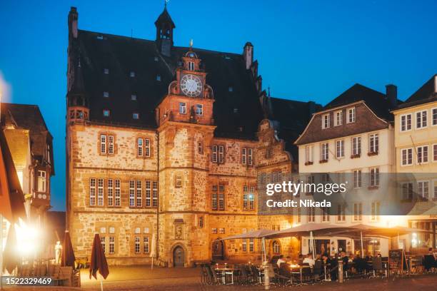 historisches gebäude des rathauses und marktplatzes in der abenddämmerung in marburg, deutschland - mittelaltermarkt stock-fotos und bilder