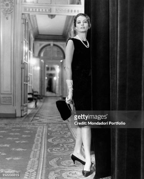 French actress and model Capucine posing in a hotel in Rome wearing a Givenchy dress. Rome, 1962