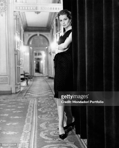 French actress and model Capucine posing in a hotel wearing a Givenchy dress. Rome, 1962