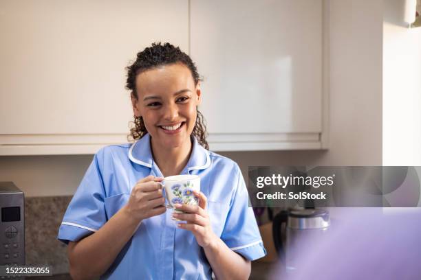 freundliche krankenschwester, die sich mit einer nicht wiederzuerkennenden person sozialisiert - nhs nurse stock-fotos und bilder