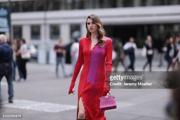 Zita d'Hauteville is seen wearing golden earrings, a long-sleeved buttoned maxi dress with a split on the side in red/pink, the Peekaboo leather bag...