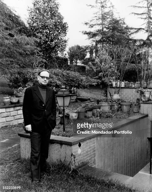 Italian conductor and composer Ennio Morricone posing in the garden. Rome, 1970s