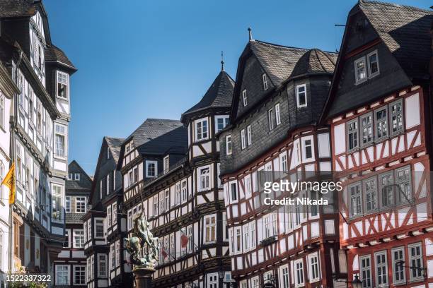 city steet with half-timbered architecture in marburg, germany - marburg germany stock pictures, royalty-free photos & images