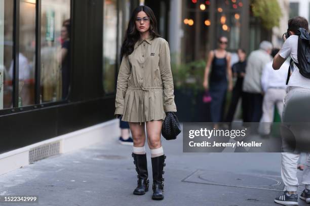 Mehrnaz Ansari is seen wearing transparent glasses, a long-sleeved khaki shirt dress with pointed collar and embroidered logo from Miu Miu, a black...