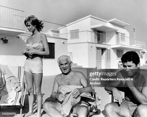 The Italian actor Gino Cervi relaxing on the seashore with his son Antonio and the Italian actress Elsa Martinelli. Fiumicino, 1960s