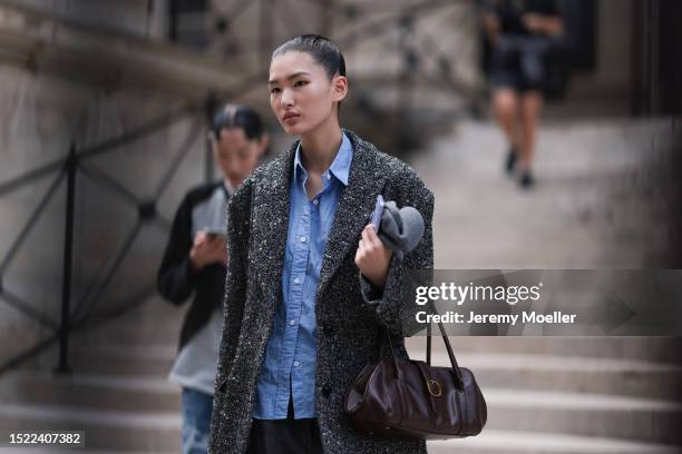 Fashion Week guest is seen a blazer with black/white pattern, a blue shirt underneath and a black leather bag outside during the Fendi Show Haute...