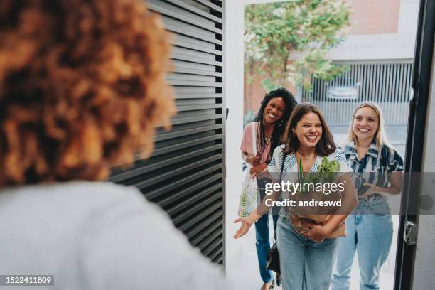 female friends arriving for a women's date - guest home stock pictures, royalty-free photos & images