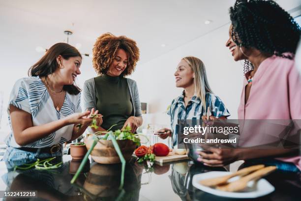 group of female friends preparing vegan lunch at home together - public kitchens stock pictures, royalty-free photos & images