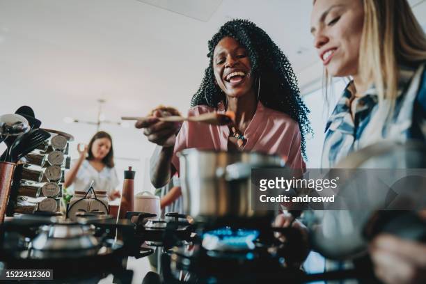group of female friends preparing vegan lunch at home together - making dinner stock pictures, royalty-free photos & images