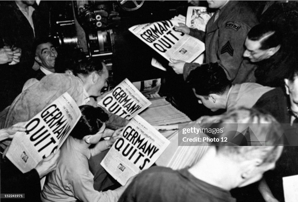Eager soldiers pull copies of 'Stars and Stripes', from the press of the London Times at 9P, M, May 7, 1945, when an extra was put out to annouce the news of Germany's total collapse, This paper was the first to hit London streets with the full story