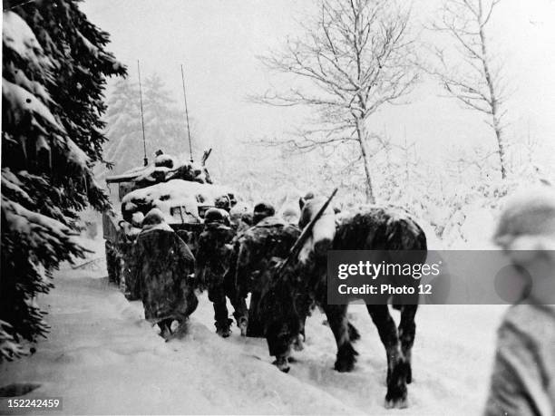 Troops of the 82nd US, Airborne Division push on in a snowstorm behind tanks January 28 to attack Herresbach , during the closing phases of the...