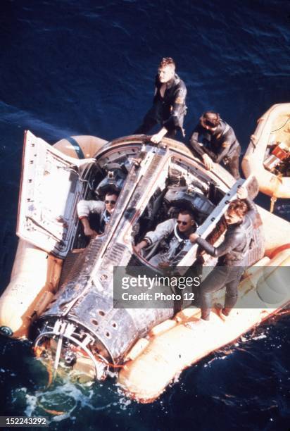Astronauts David Scott and Neil Armstrong sits inside their Gemini 8 spacecraft afloat in the Pacific Ocean .