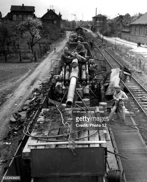 Members of the 712th US, Railway Operating Battalion examine a German 5 inch railway gun in Hanau April 15, 1945.