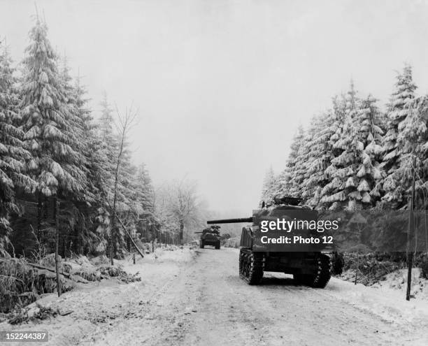 Their 75mm, guns alert for a flank attack, these 3rd US, Armored Division Sherman tanks wait on snow-covered road Manhay-Houffalize, January 7, 1945.