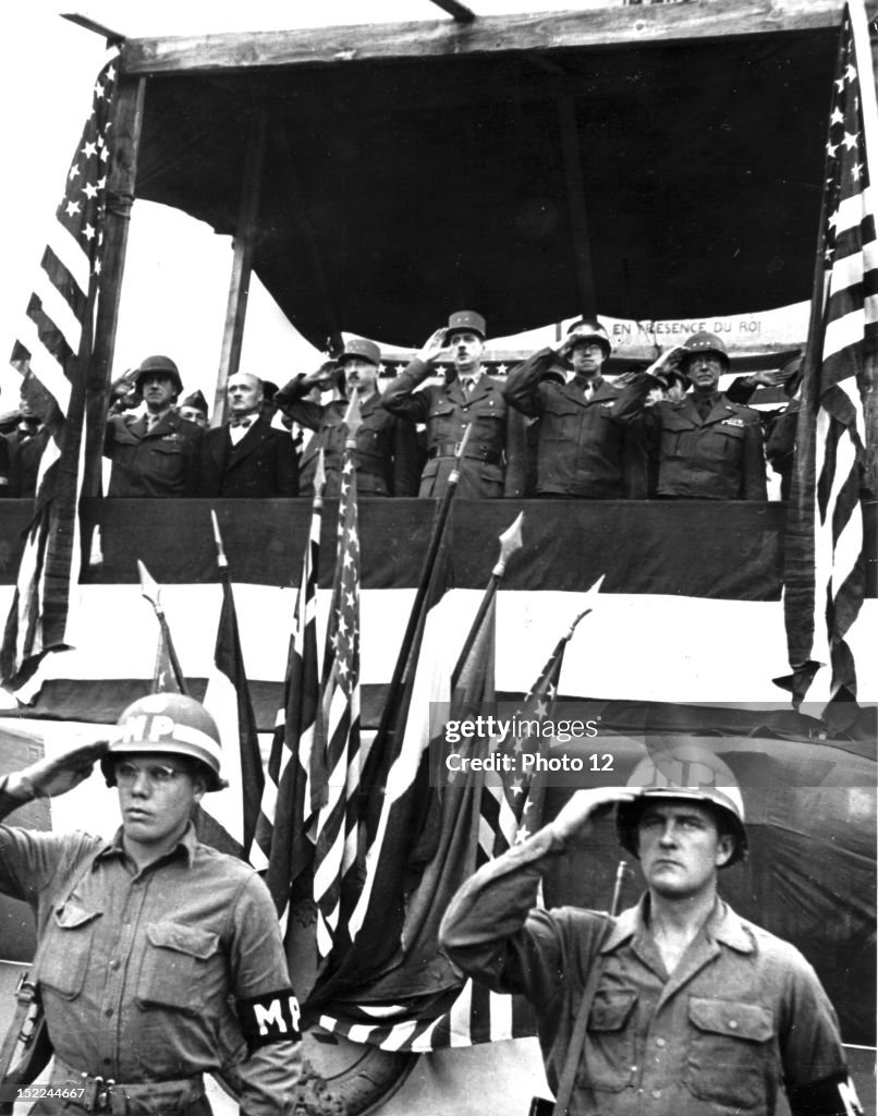 Left to right, US, Major General Leonard T, Gerow, Andre Le Troquer, French General Joseph Pierre Koenig, General de Gaulle, US, Lieutenant General Omar N, Bradley and US, Lieutenant General Courtney H, Hodges standing side by side salute US, troops