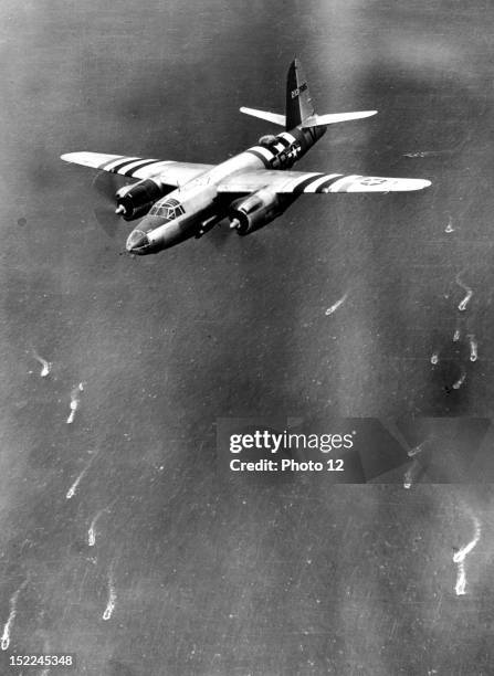 Bearing special striped markings on wings and fuselage, a B-26 Marauder bomber of the 9th US, Air Force charges at low altitude over the English...