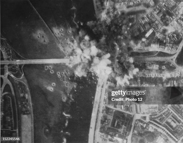 Heavy smoke from bomb bursts covers the highway bridge at Arnhem as B-26 Marauders of the 9th US, Air Force score direct hits .