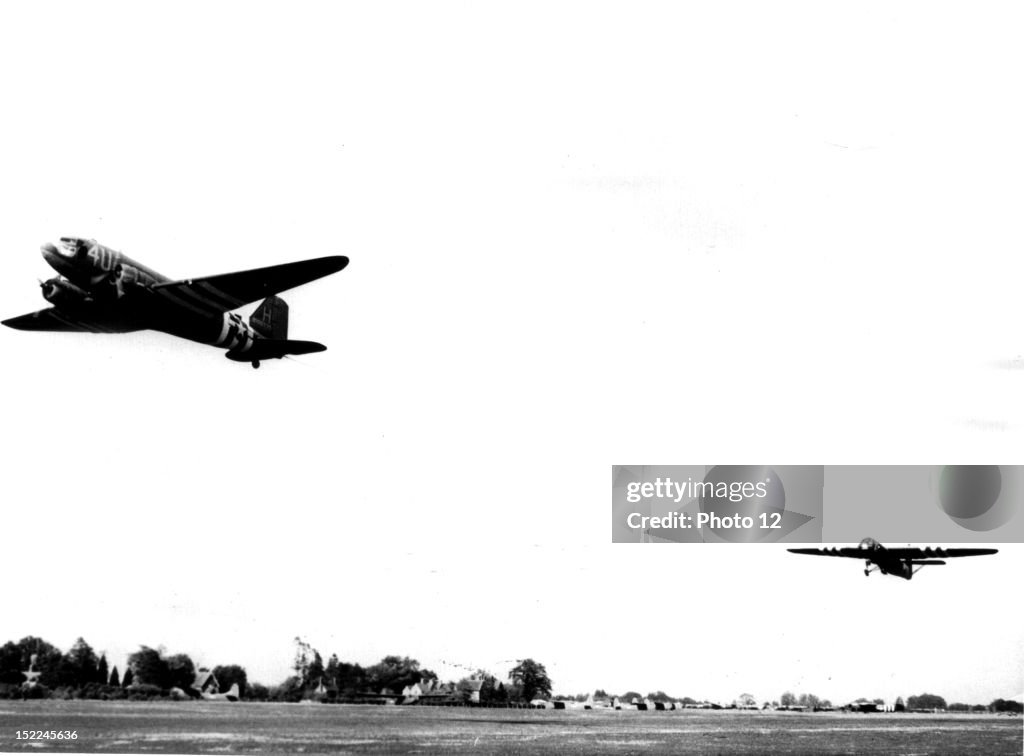 A C-47 transport towing a glider load of US, airborne infantry takes off from a 9th US, Air Force Troop Carrier Command station in England to support of Allied paratroopers dropped behind enemy line in Normandy