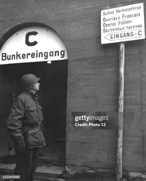 An American officer looks at foreigners languages signs at the entrance to slave labor barracks at the Daimler-Benz auto factory at Mannheim April 6,...