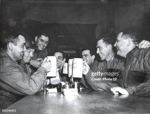 Members of the 63rd Division, 7th US, Army who captured Heidelberg March 30 sample the beer for which the ancient German university is famous.
