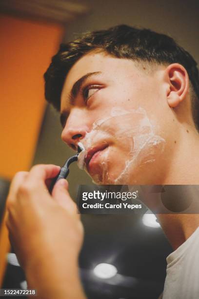 young male  using a manual razor - male hair removal stock-fotos und bilder