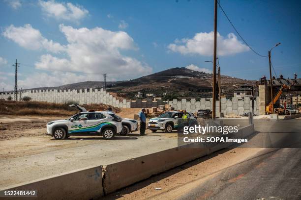 Palestinian and Israeli workers install a bridge in the town of Hawara, south of Nablus. The bridge is being built for the benefit of residents of...