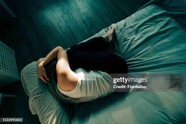 portrait of a woman lying on the sofa - embryo position stock pictures, royalty-free photos & images