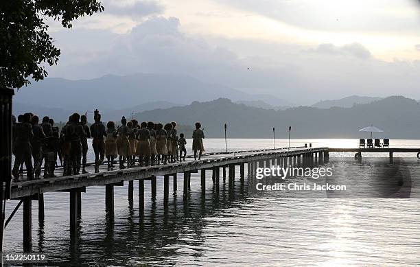Dancers walk to the end of a pier after giving a traditional greeting to the royal couple as they visit Tuvanipupu Island on their Diamond Jubilee...