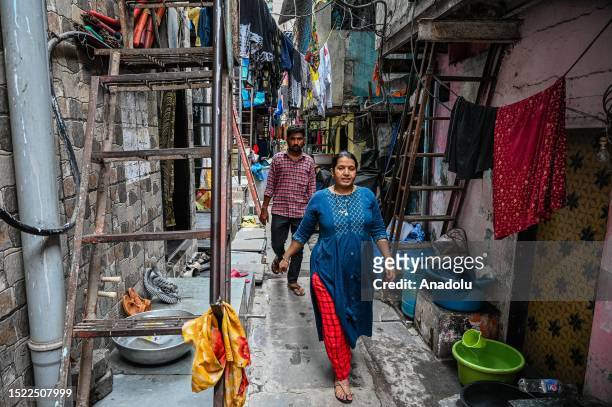 People walk through an alley in between densely-built houses on the eve of World Population Day , at Dharavi slum area in Mumbai, India on July 08,...