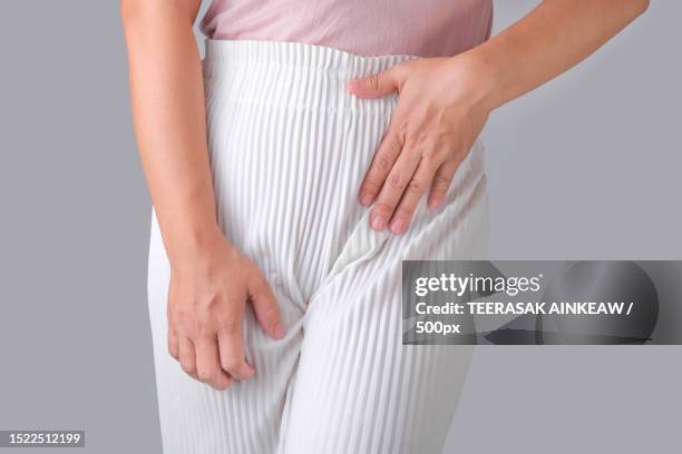 midsection of woman with stomachache standing against gray background - underliv bildbanksfoton och bilder